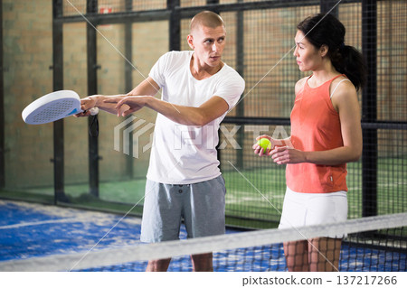 Portrait of concentrated trainer teaching young player 137217266