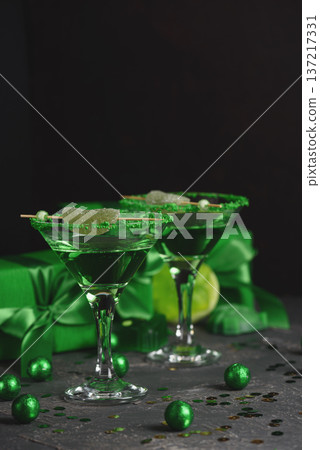 Green Cocktails with Lime,  Gifts and Confetti. Festive St. Patricks Day Celebration Still Life 137217331