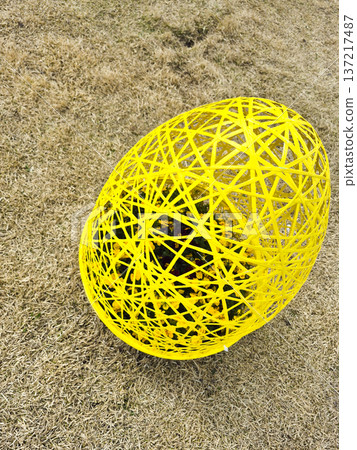 Vibrant egg shaped string planter of blooming pansies in a sunny park during Easter time in the spring Vibrant egg shaped string planter of blooming pansies in a sunny park during Easter time in the spring 137217487