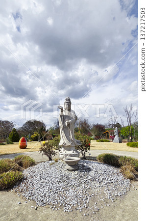 Stone statue of a deity in a sunny park during the Easter holidays in spring. The concept of religious diversity and tolerance. Stone statue of a deity in a sunny park during the Easter holidays in spring. The concept of religious diversity and tolerance. 137217503