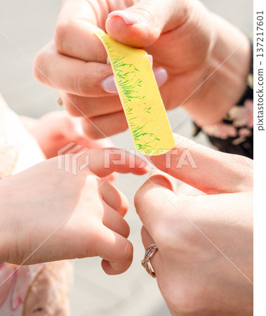 Child wound treatment. Toddler finger protected by caregiver. Parenting responsibility concept. 137217601