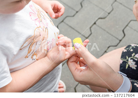 Child wound care. Toddler finger protected with adhesive strip. Parenting safety concept. 137217604