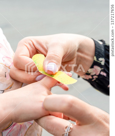 Child first aid. Toddler finger treated by parent hands. Home healthcare concept. 137217656