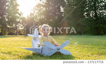 Airplane costume. Toddler imagination flying. Girl outdoor yellow grass fun. Airplane costume. Toddler imagination flying. Girl outdoor yellow grass fun. 137217716