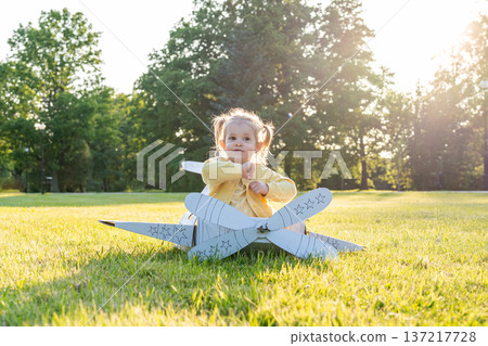 Cardboard pilot. Girl dress-up play child. Park dream aviation outdoor. Cardboard pilot. Girl dress-up play child. Park dream aviation outdoor. 137217728