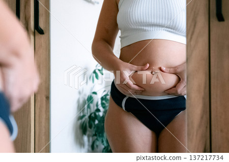 Female torso. Overweight abdomen detail. Real beauty concept Female torso. Overweight abdomen detail. Real beauty concept 137217734