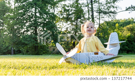Airplane costume. Toddler imagination flying. Girl outdoor yellow grass fun. Airplane costume. Toddler imagination flying. Girl outdoor yellow grass fun. 137217744