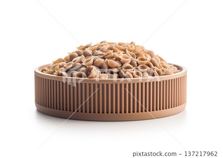 Wholegrain conchiglie pasta in bowl isolated on white background. Wholegrain conchiglie pasta in bowl isolated on white background. 137217962