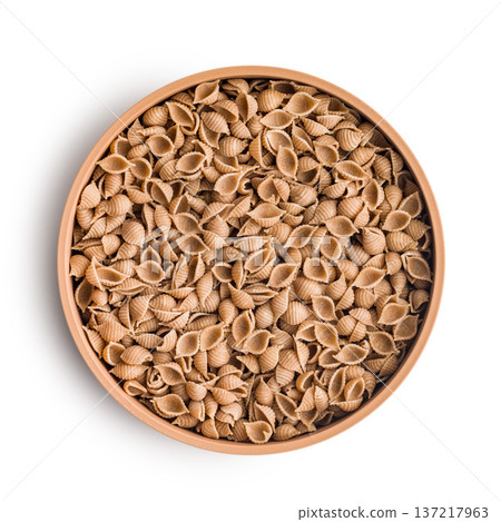 Wholegrain conchiglie pasta in bowl isolated on white background. 137217963