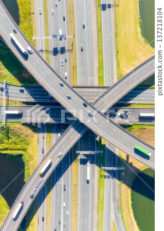 Aerial view of a multilevel highway interchange with busy car traffic. Vertical photo. 137218104
