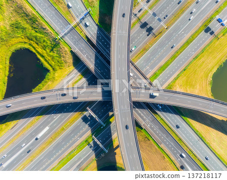 Aerial view of a multilevel highway interchange with busy car traffic. Aerial view of a multilevel highway interchange with busy car traffic. 137218117