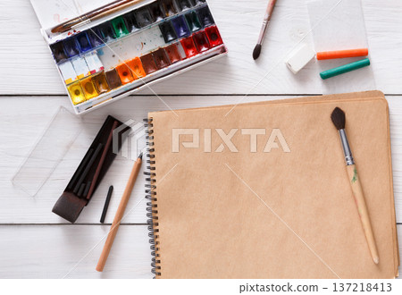 Artist working space background. Watercolor paints and blank craft paper on white wooden desk, top view, flat lay, copy space 137218413