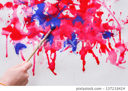Artist creating watercolor painting. Expressive brush strokes of red and blue on paper texture. Modern art backgroung with copy space 137218424