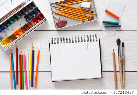 Workplace of artist with copy space. Paints, sketchbook and brushes on white desk, top view, flat lay, objects 137218457