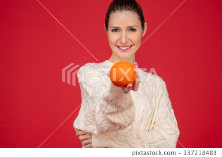 Smiling and happy young woman with fruits in hands Smiling and happy young woman with fruits in hands 137218483