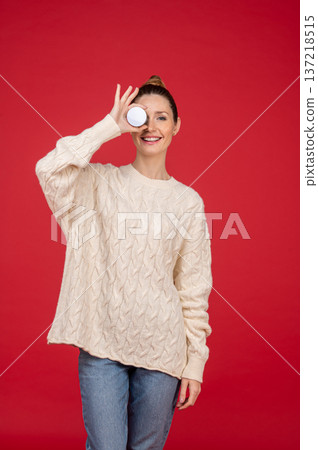 Beautiful young woman on red background with a jar of cream in hand Beautiful young woman on red background with a jar of cream in hand 137218515