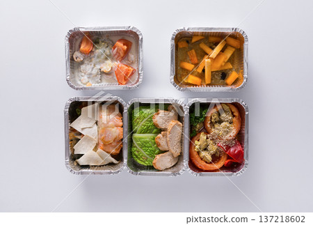 Healthy food delivery. Take away of natural fitness dishes for diet. Daily meals in foil boxes on white background 137218602