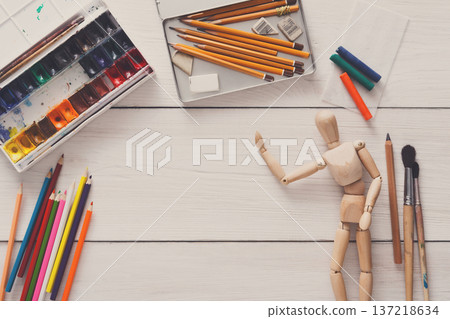 Painting visual art background. Paints and wooden painter man with brushes on white desk, top view, flat lay, objects Painting visual art background. Paints and wooden painter man with brushes on white desk, top view, flat lay, objects 137218634