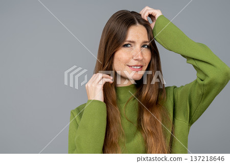 Pretty young caucasian woman in green on a grey background 137218646