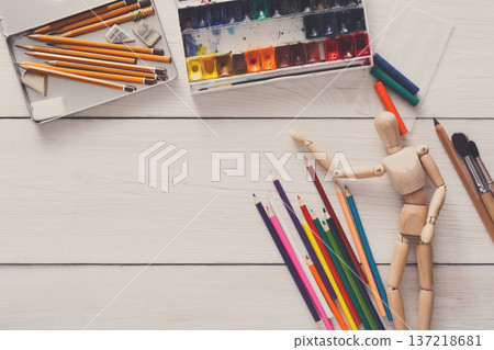 Painting visual art background. Paints and wooden painter man with brushes on white desk, top view, flat lay, objects Painting visual art background. Paints and wooden painter man with brushes on white desk, top view, flat lay, objects 137218681