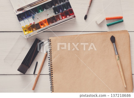 Artist working space background. Watercolor paints and blank craft paper on white wooden desk, top view, flat lay, copy space 137218686