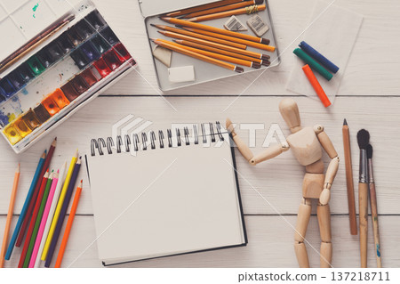 Painting visual art background. Paints and wooden painter man with brushes on white desk, top view, flat lay, objects Painting visual art background. Paints and wooden painter man with brushes on white desk, top view, flat lay, objects 137218711
