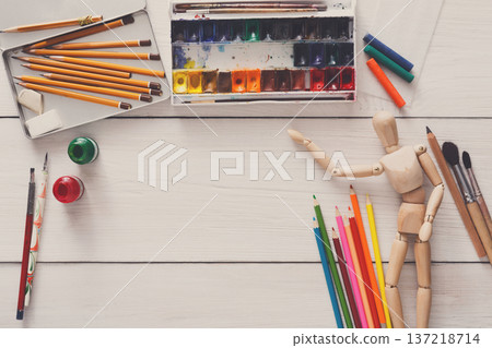 Painting visual art background. Paints and wooden painter man with brushes on white desk, top view, flat lay, objects Painting visual art background. Paints and wooden painter man with brushes on white desk, top view, flat lay, objects 137218714