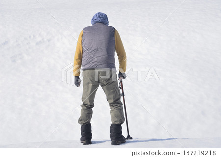 An elderly man doing rehabilitation using a walking stick on the snow An elderly man doing rehabilitation using a walking stick on the snow 137219218