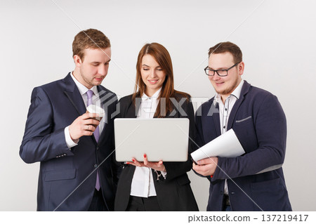 Brainstorm. Group of cheerful business people looking at laptop together and smiling. Successful project concept 137219417