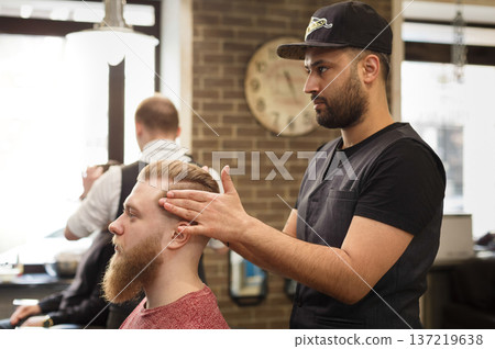 Styling hairdress to client. Male barbershop. Modern hairdresser in men hair salon Styling hairdress to client. Male barbershop. Modern hairdresser in men hair salon 137219638