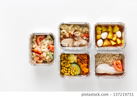 Healthy daily meals, food delivery. Take away of natural fitness dishes for diet. Lunch in foil boxes on white background Healthy daily meals, food delivery. Take away of natural fitness dishes for diet. Lunch in foil boxes on white background 137219731