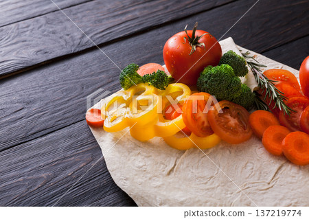 Cooking healthy vegetarian food background. Fresh organic vegetables on pita bread. Natural food with copy space. Cooking healthy vegetarian food background. Fresh organic vegetables on pita bread. Natural food with copy space. 137219774
