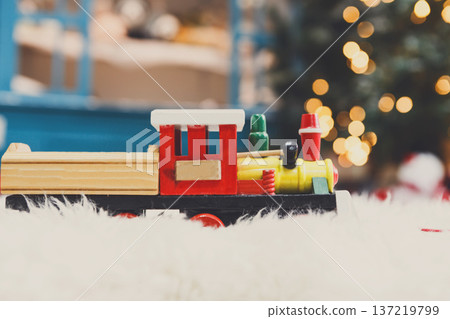 Wooden toy train on snowy decorated background. Selective focus, copy space 137219799