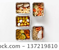 Multiple meal prep containers are filled with nutritious food items, showcasing a variety of colors and textures. Each container has different ingredients including grains, vegetables, and proteins. 137219810