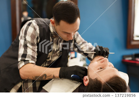 Barber styling beard with razo ershop, closeup. Barbershop for men Barber styling beard with razo ershop, closeup. Barbershop for men 137219856