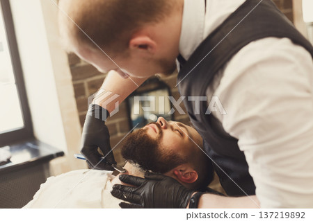 Barber in barbershop make beard haircut, shaving. Hairstyle in male hair salon 137219892