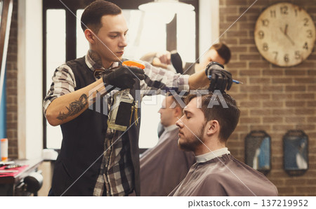 Spraying water, haircut in modern male barbershoip. Stylish barber and client 137219952