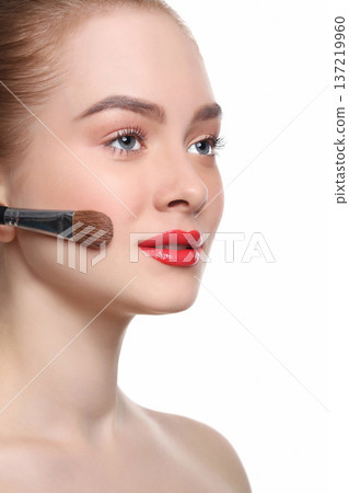 Beauty, cosmetics, finish make-up, powder brush. Woman applying base foundation primer on face, white background 137219960