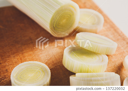 Cooking healthy food. Sliced and chopped leek closeup on wood background Cooking healthy food. Sliced and chopped leek closeup on wood background 137220032