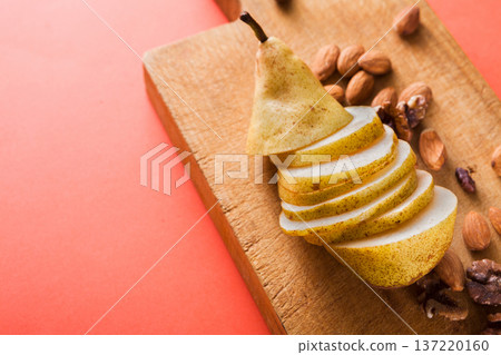 Healthy food, fruit background. Sliced pear with almonds on wooden board, selective focus, nobody, diet and vegetarian concept Healthy food, fruit background. Sliced pear with almonds on wooden board, selective focus, nobody, diet and vegetarian concept 137220160