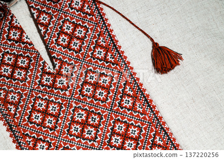 Traditional Ukrainian embroidery with red, black, and white geometric patterns on linen fabric Traditional Ukrainian embroidery with red, black, and white geometric patterns on linen fabric 137220256