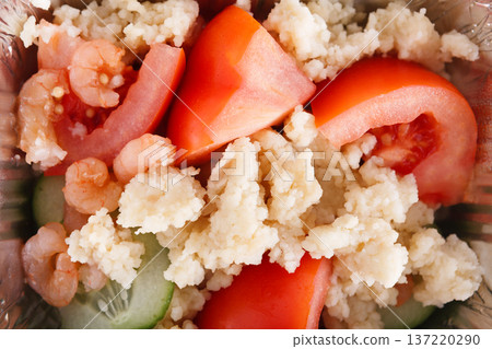 A vibrant salad features peeled shrimp, diced tomatoes, and cucumber, all mixed with fluffy grain. The colorful ingredients create a light and refreshing dish, perfect for a healthy meal. A vibrant salad features peeled shrimp, diced tomatoes, and cucumber, all mixed with fluffy grain. The colorful ingredients create a light and refreshing dish, perfect for a healthy meal. 137220290