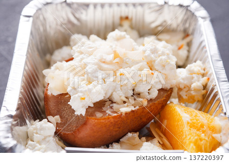 Healthy lunch in foil container, dieting and detox concept. Cottage cheese, persimmon and mandarin, close up Healthy lunch in foil container, dieting and detox concept. Cottage cheese, persimmon and mandarin, close up 137220397