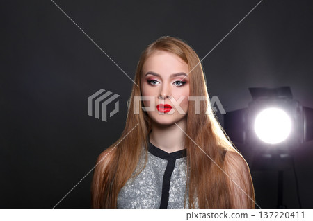 Fashion backstage. Beautiful woman model on black background with copy space. Girl with makeup, perfect skin and hair posing to camera at studio Fashion backstage. Beautiful woman model on black background with copy space. Girl with makeup, perfect skin and hair posing to camera at studio 137220411