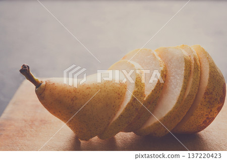Sliced pear on wooden board background, selective focus, copy space, healthy food, diet and vegetarian concept 137220423