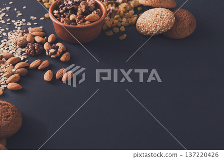 Healthy organic oat cookies made of wholegrain oat and nuts on dark table background, copy space. Flat lay, mockup. Healthy organic oat cookies made of wholegrain oat and nuts on dark table background, copy space. Flat lay, mockup. 137220426