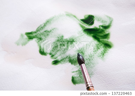 Artist creating watercolor painting. Expressive brush strokes of green aquarelle on paper texture. Modern art backgroung with copy space Artist creating watercolor painting. Expressive brush strokes of green aquarelle on paper texture. Modern art backgroung with copy space 137220463