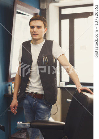 Barber wait for client. Young professional haitstylist in male barbershop 137220552