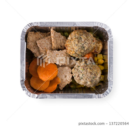 Healthy lunch in foil container. Healthy food take away and delivery. Rusks, cutlets, corn, carrot, green pea in box on white background, closeup, isolated Healthy lunch in foil container. Healthy food take away and delivery. Rusks, cutlets, corn, carrot, green pea in box on white background, closeup, isolated 137220564
