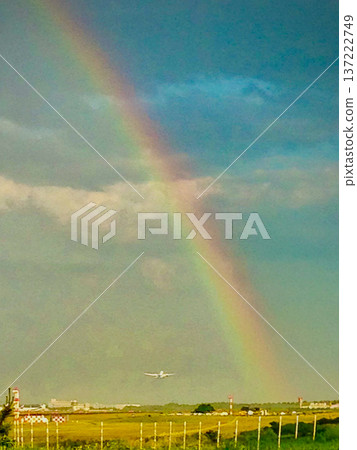 A rainbow appears after a passing shower and an airplane takes off. Airport scenery. A rainbow appears after a passing shower and an airplane takes off. Airport scenery. 137222749